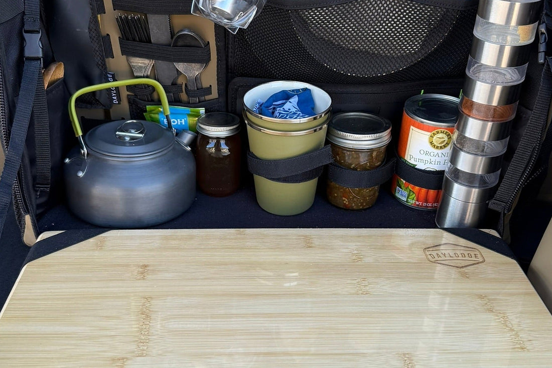 Close view of a fitted camp kitchen module in a van, chopping board and stores in place