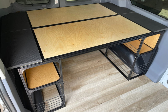 A powder coated bed platform frame with finished ply deck beside a van