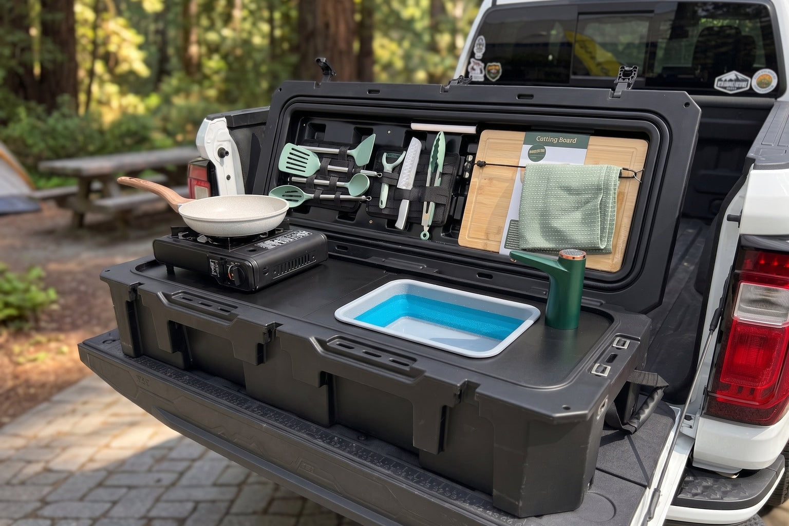 A camp kitchen case set up at the rear of a van