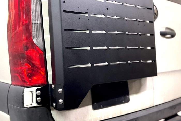 A laser cut black aluminium slotted panel shown as a product beside a van