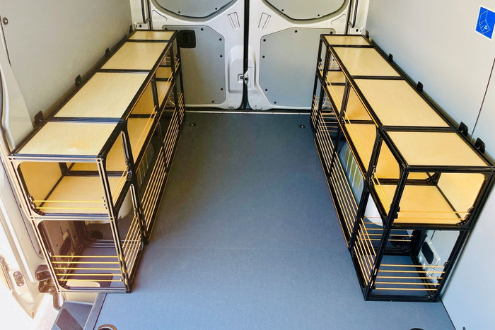 Tube and plywood shelving bolted along a van wall