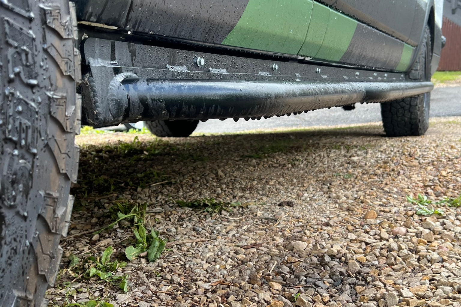 A wide textured step plate fitted beneath the sliding door of a high-roof cargo van