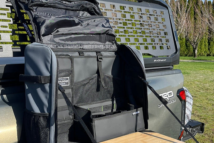 Soft organizer case with mesh pockets open on a tailgate