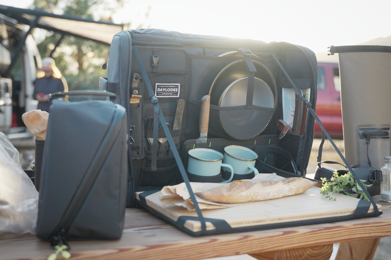 Camp kitchen case open on a picnic table at golden hour