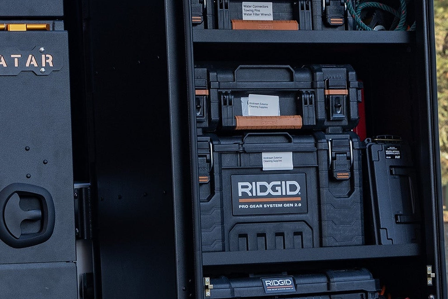 A drawer unit and storage bins loaded in the cargo bay of a modern high-roof van seen through the open rear doors