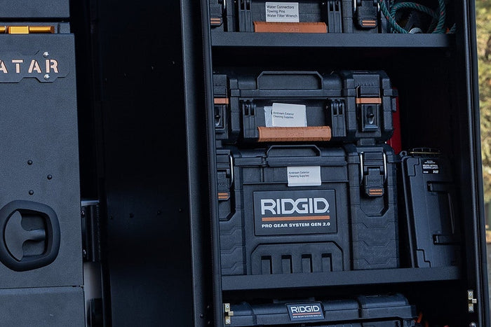 A drawer unit and storage bins loaded in the cargo bay of a modern high-roof van seen through the open rear doors