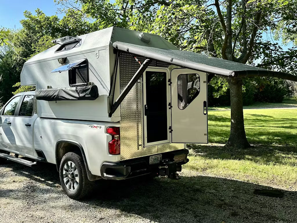 Rear view of the DAYLODGE AirHaven 40 Vehicle Shelter System, part of a vehicle based camp and travel setup