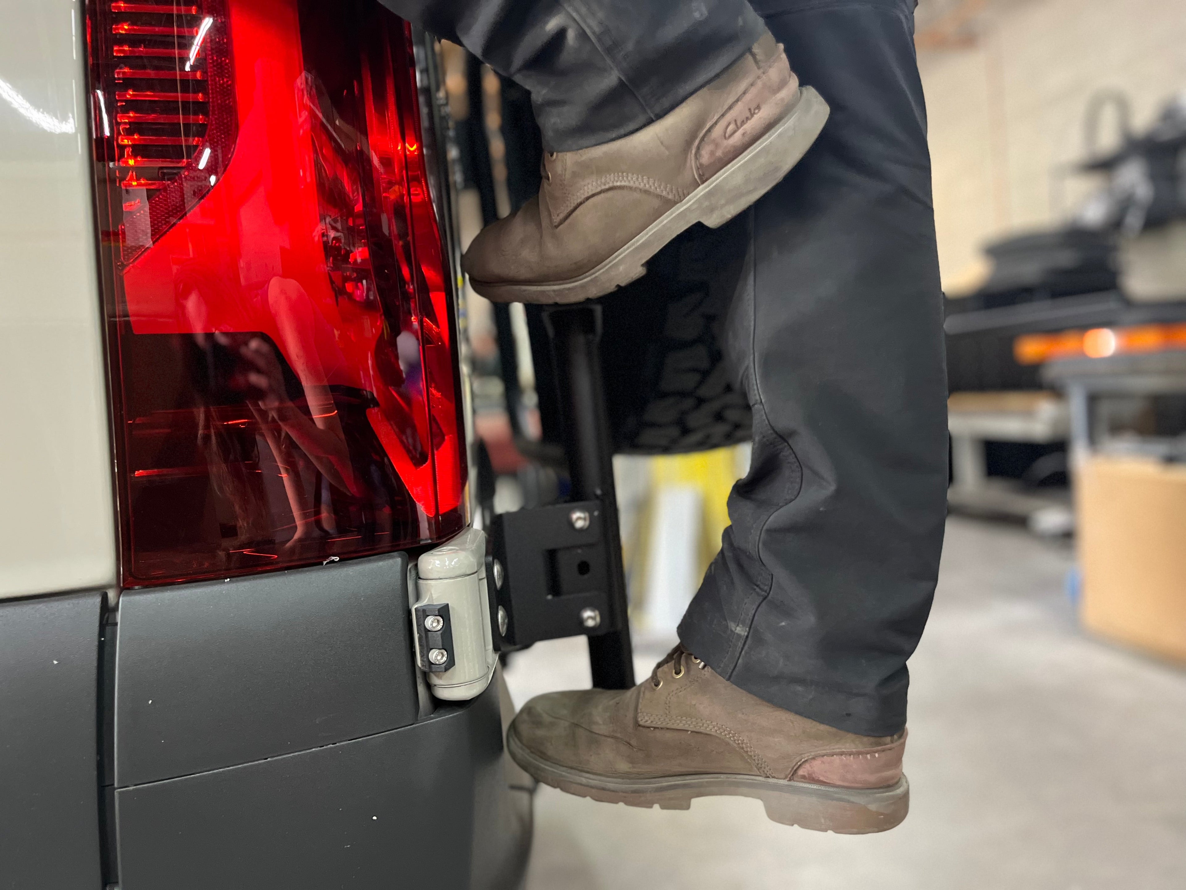 Wider view of the Avatar Offroad Rear Ladder with Tire Carrier for Vans, fitted to an overland van build