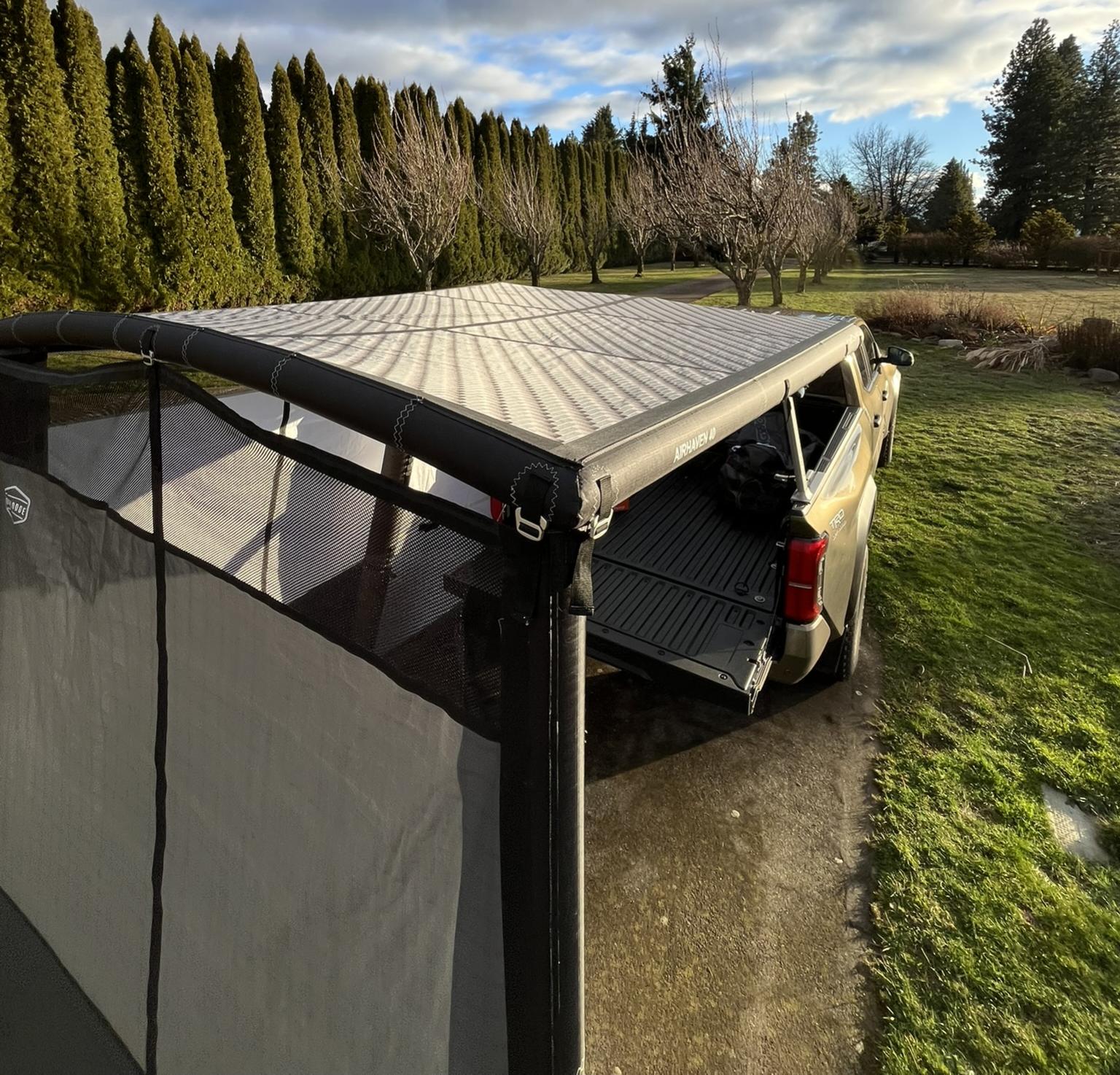 In use view of the DAYLODGE AirHaven 40 Annex Wall Kit, part of a vehicle based camp and travel setup